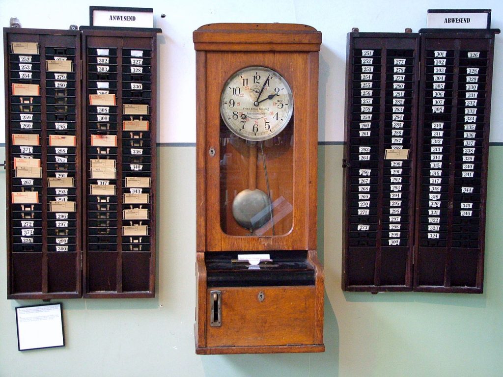 Una antigua máquina de fichado de entrada y salida del trabajo, para control de los empleados, con sus casilleros para las tarjetas