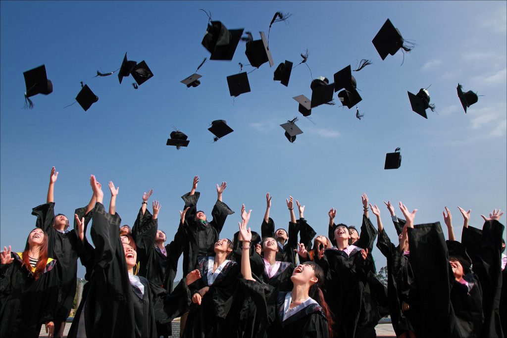educación universitaria Un grupo de estudiantes lanza al aire sus birretes de graduación